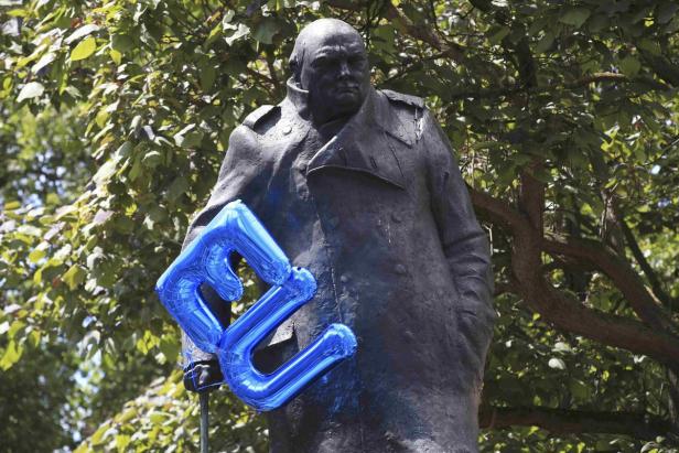 Eine Statue von Winston Churchill mit einem blauen EU-Luftballon.
