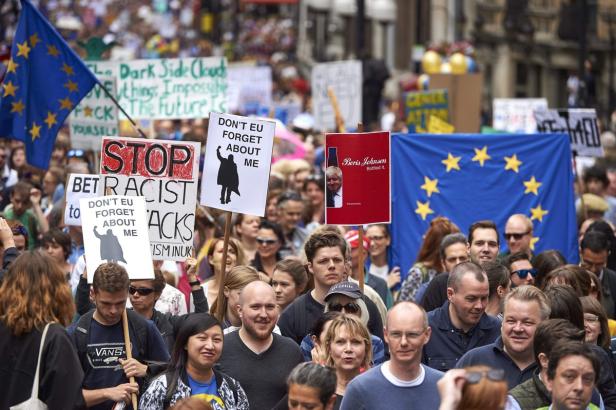 Eine Demonstration mit EU-Flaggen und Schildern gegen Rassismus und mit Kritik an Boris Johnson.