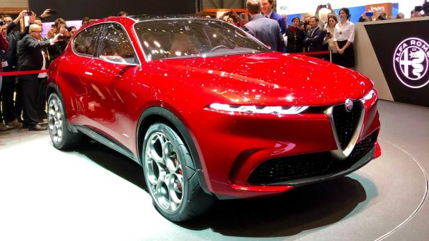 Ein roter Alfa Romeo Tonale steht auf einer Automobilausstellung.