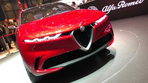 Nahaufnahme der Front eines roten Alfa Romeo auf einer Automobilausstellung.