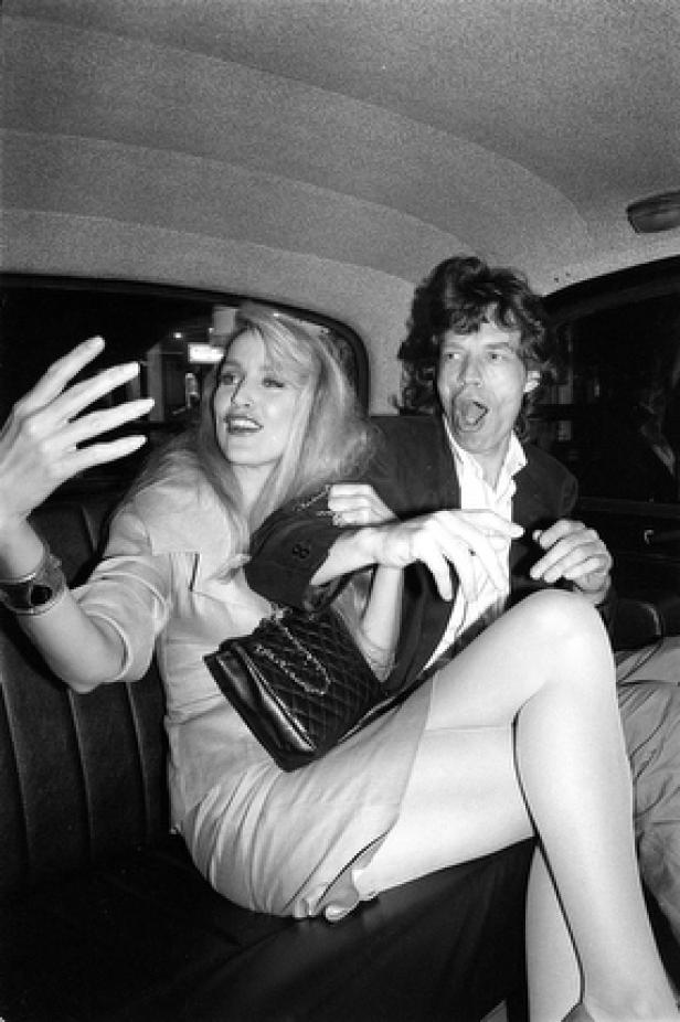 Jerry Hall und Mick Jagger sitzen in einem Taxi.
