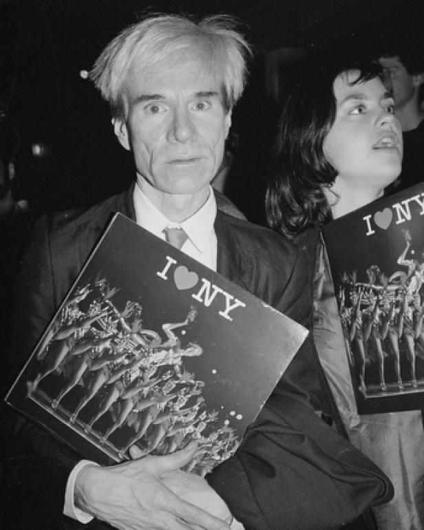 Andy Warhol hält eine „I Love NY“-Platte in der Hand.