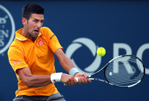 Novak Đoković schlägt einen Tennisball während eines Spiels.