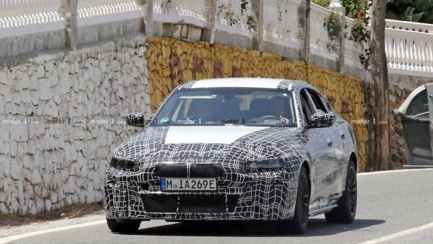 Ein getarntes BMW-Fahrzeug fährt auf einer Straße.