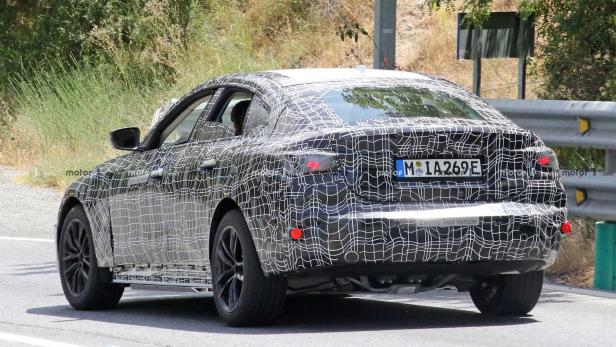 Ein Prototyp eines BMW mit Tarnmuster auf einer Straße.