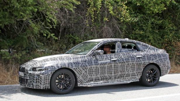 Ein Prototyp eines BMW mit Tarnmuster fährt auf einer Straße.