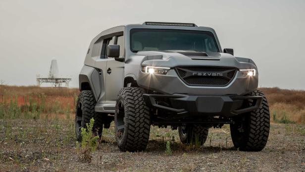 Ein grauer Rezvani Tank SUV steht im Gelände vor einer Radaranlage.
