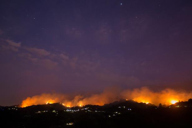 Flames and smoke from a forest fire are seen in the village of Moya in the Canary Island of Gran Canaria