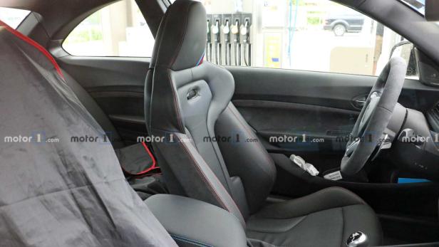 Das Interieur eines Autos mit Sportsitzen und einem Alcantara-Lenkrad.