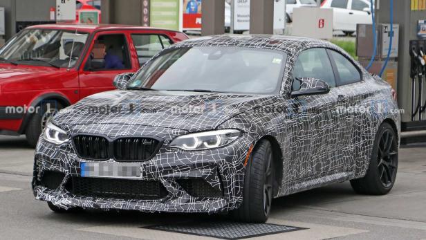 Ein getarntes BMW M2 Coupé steht an einer Tankstelle.