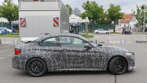 Ein Prototyp des neuen BMW 2er Coupé mit Tarnmuster auf einer Straße.