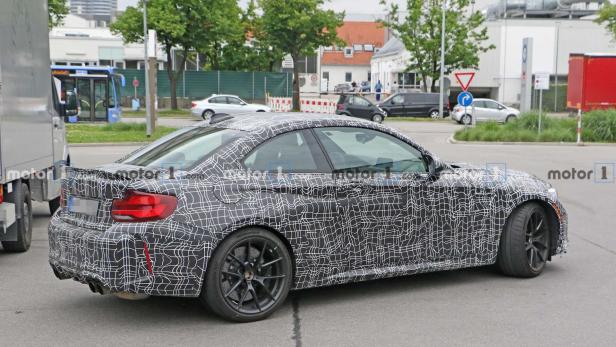 Ein getarntes BMW M2 Coupé fährt auf einer Straße.