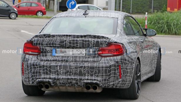 Ein Prototyp eines BMW M2 mit Tarnmuster auf einer Straße.