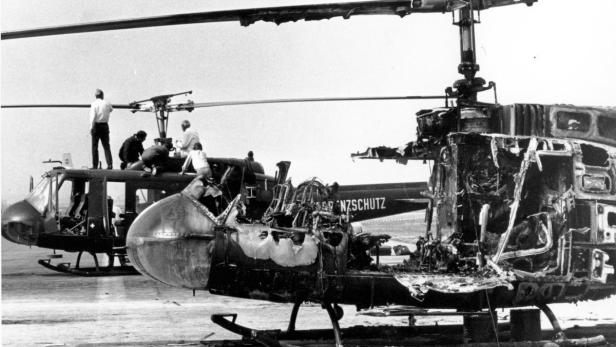 Ein zerstörter Hubschrauber des Bundesgrenzschutzes steht neben einem intakten Hubschrauber.