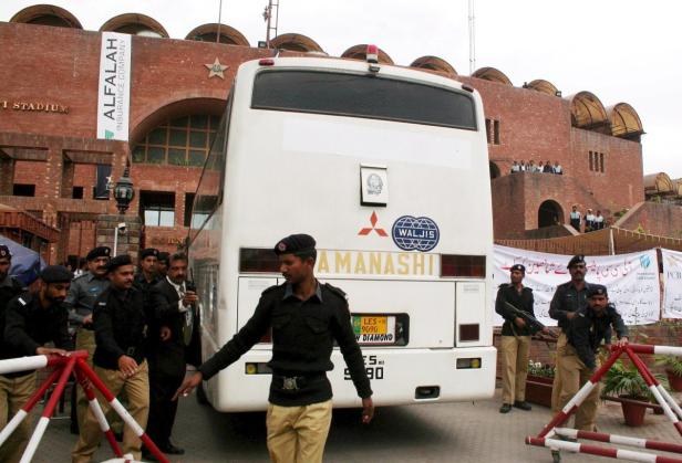 Bewaffnete Sicherheitskräfte bewachen einen Bus vor dem Gaddafi-Stadion in Lahore, Pakistan.