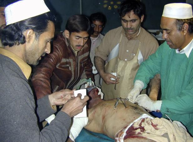 Ärzte behandeln einen verletzten Mann mit blutigen Wunden.