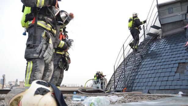 Feuerwehrleute arbeiten auf dem Dach eines Gebäudes.