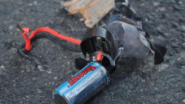 Eine beschädigte Tenergy-Batterie mit freiliegenden Kabeln liegt auf dem Boden.