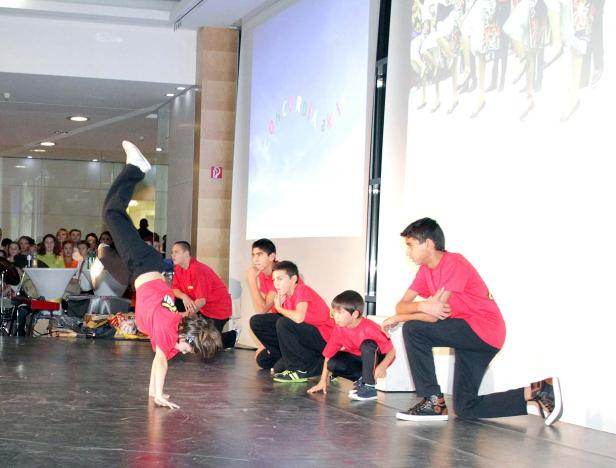 Eine Breakdance-Gruppe tritt vor Publikum auf einer Bühne auf.