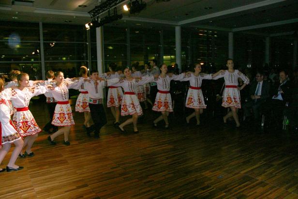 Eine Gruppe von Tänzern in Trachten führt einen traditionellen Tanz auf.