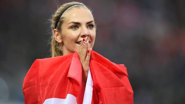 Mujinga Kambundji mit der Schweizer Flagge nach einem Wettkampf.