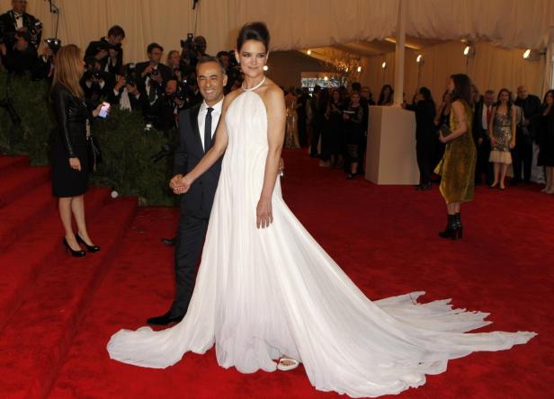 Katie Holmes in einem weißen Kleid mit Schleppe auf einem roten Teppich.