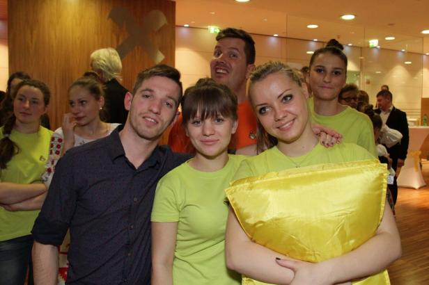 Eine Gruppe junger Leute posiert für ein Foto in einem Innenraum.