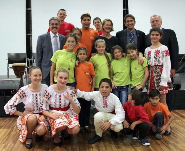 Eine Gruppe von Kindern und Erwachsenen posiert in traditioneller Kleidung für ein Foto.
