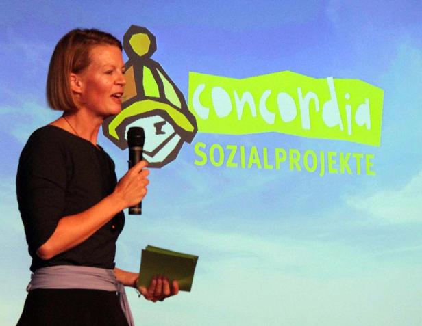 Eine Frau spricht bei einer Veranstaltung von Concordia Sozialprojekte.