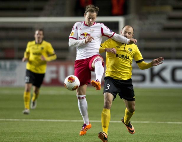 Zwei Fußballspieler kämpfen um den Ball während eines Spiels.