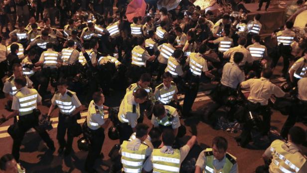 Eine große Gruppe Polizisten steht auf einer Straße.