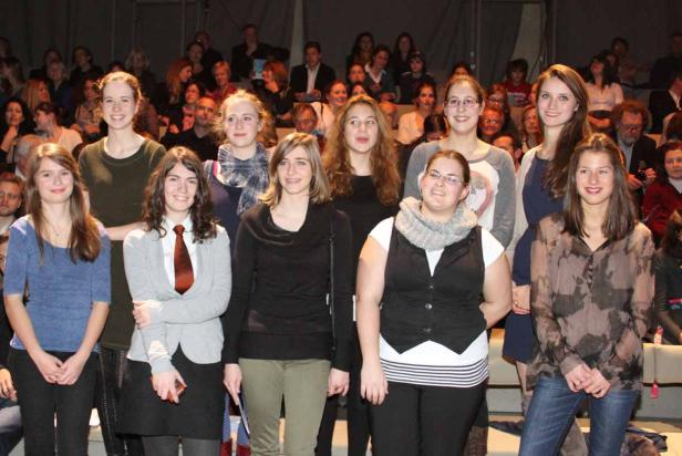 Eine Gruppe junger Frauen steht vor einem Publikum.