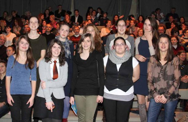 Eine Gruppe junger Frauen steht vor einem Publikum.