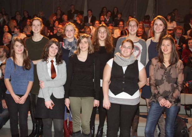 Eine Gruppe junger Frauen steht vor einem Publikum.