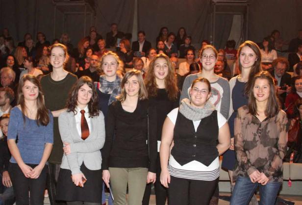 Eine Gruppe junger Frauen steht vor einem Publikum.