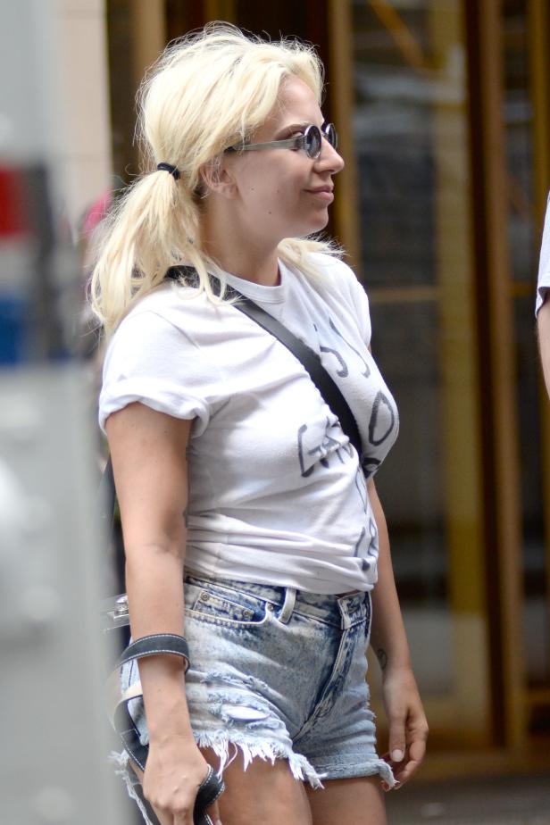 Lady Gaga mit blonden Haaren, T-Shirt und Jeansshorts auf der Straße.