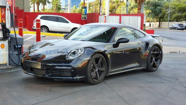 Ein schwarzer Porsche steht an einer Tankstelle.