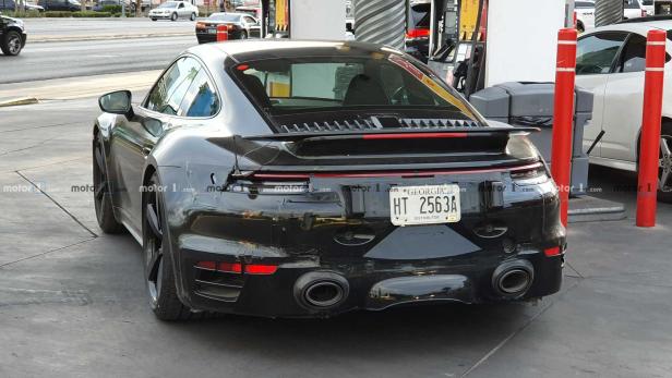 Ein schwarzer Porsche parkt an einer Tankstelle.