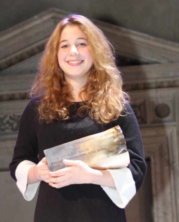 Johanna Fuchs hält eine Auszeichnung des Rainer Gymnasiums, 1050 Wien, in den Händen.