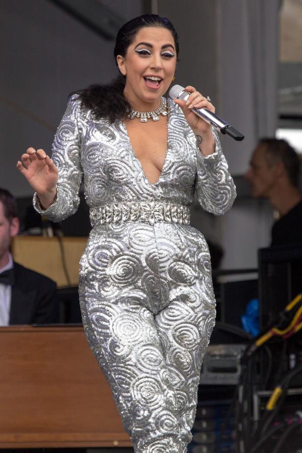Lady Gaga tritt in einem glitzernden silbernen Overall auf die Bühne.