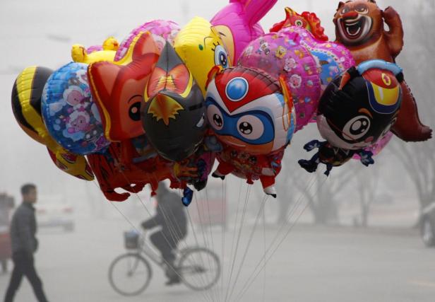 Eine Gruppe bunter, heliumgefüllter Comic-Figuren-Ballons schwebt in der Luft.