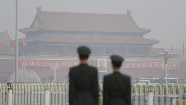 Zwei Soldaten vor dem Tian’anmen-Platz in Peking mit einem Porträt von Mao Zedong.