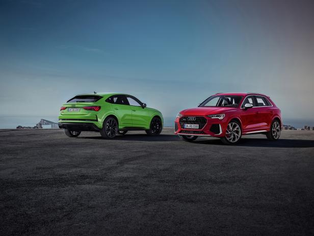 Ein grüner und ein roter Audi Q3 stehen vor einem blauen Himmel.