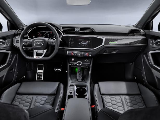 Innenraum eines Audi RS Q3 mit schwarzen Ledersitzen und digitalem Cockpit.
