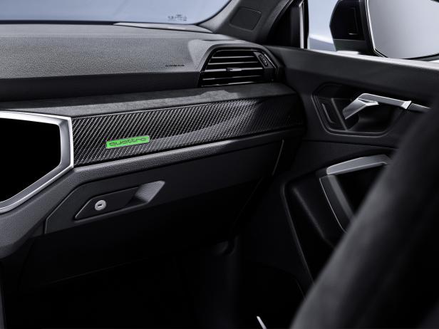 Detailaufnahme des Armaturenbretts eines Autos mit Carbon-Akzenten und „Quattro“-Logo.