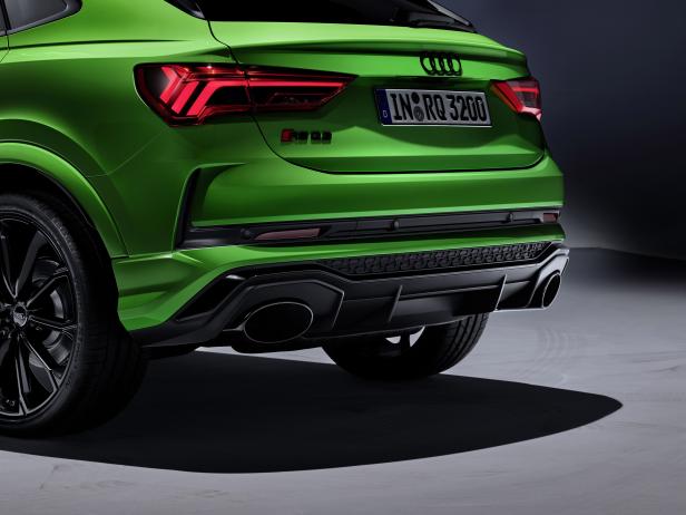 Die Rückansicht eines grünen Audi RS Q3 mit markanten Rückleuchten und Auspuffrohren.