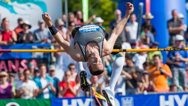 Ein Hochspringer überquert die Latte vor einer Zuschauermenge.