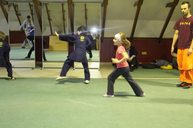 Kinder üben Kung Fu in einer Turnhalle.
