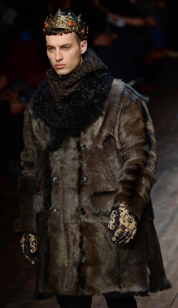 Ein Mann mit Krone und Pelzmantel auf einem Laufsteg.