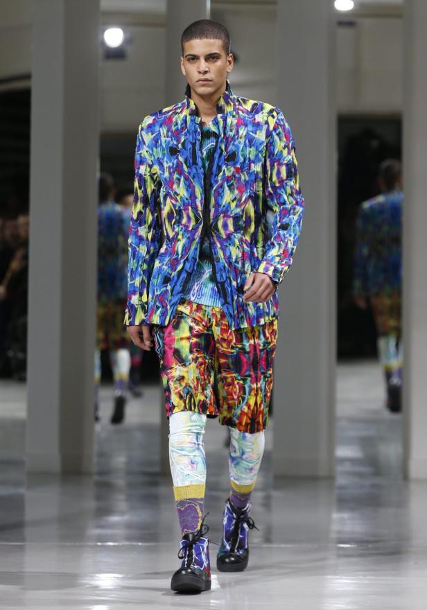Ein Mann in einem farbenfrohen Anzug auf einem Laufsteg.